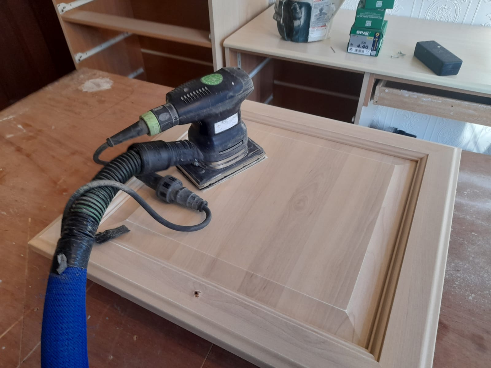 Photo of a decorators professional 99% dust free sander being used to sand down a kitchen cabinet ready for the kitchen to be hand painted